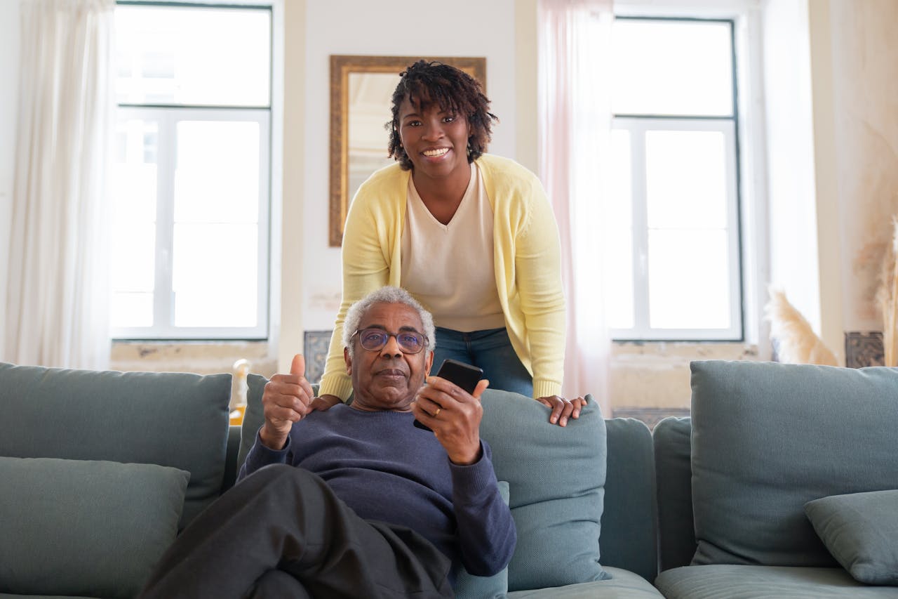 Smiling senior man and caregiver share a joyful moment at home.